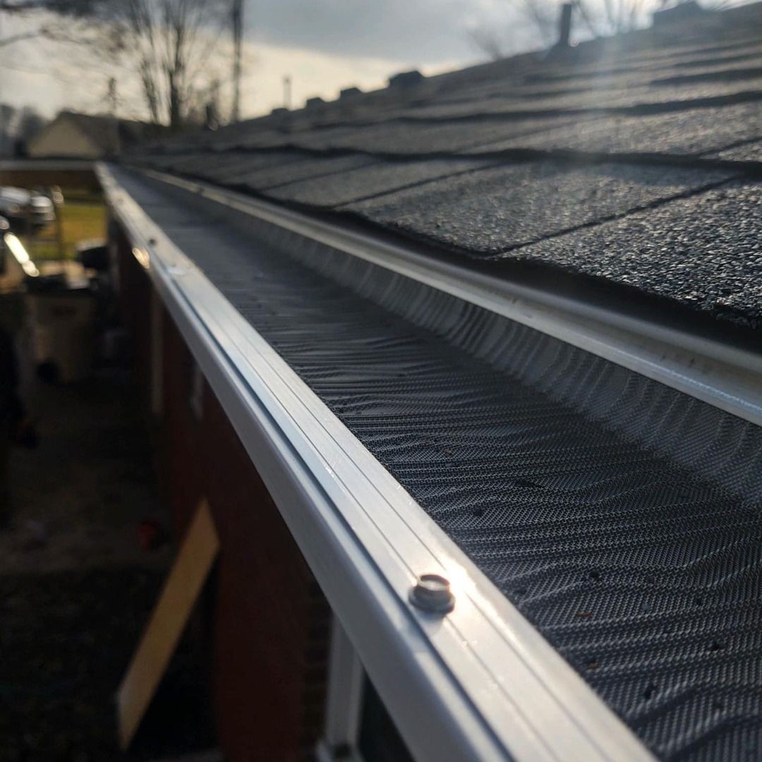 Close-up view of a roof with an aluminum gutter guard installed to protect against debris accumulation.